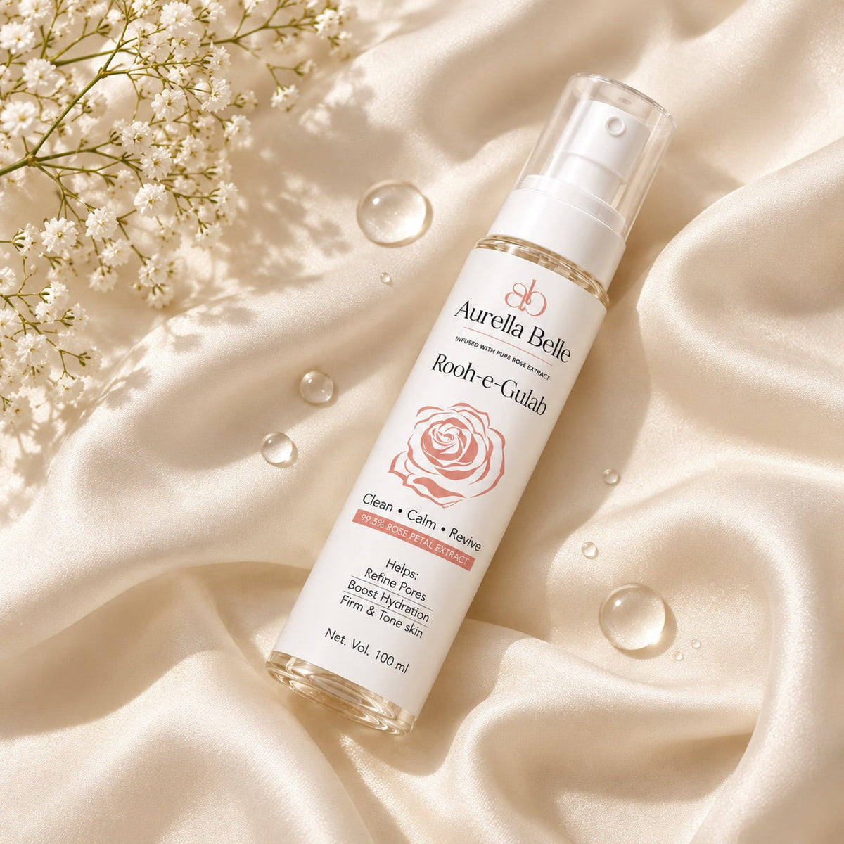 Rose water bottle on cream silk with water droplets